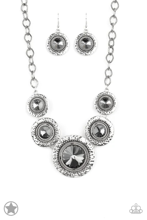 Silver necklace and earrings set with black gemstones on a white background