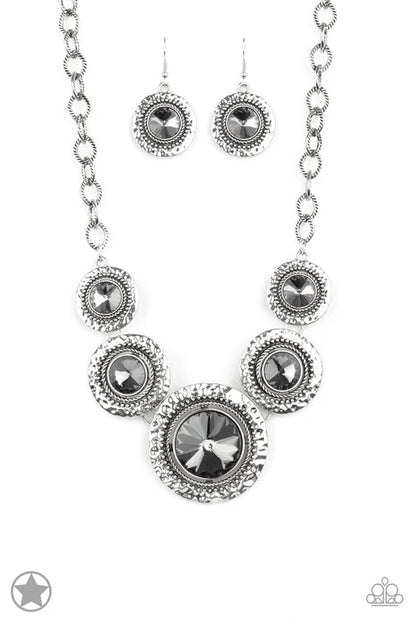 Silver necklace and earrings set with black gemstones on a white background
