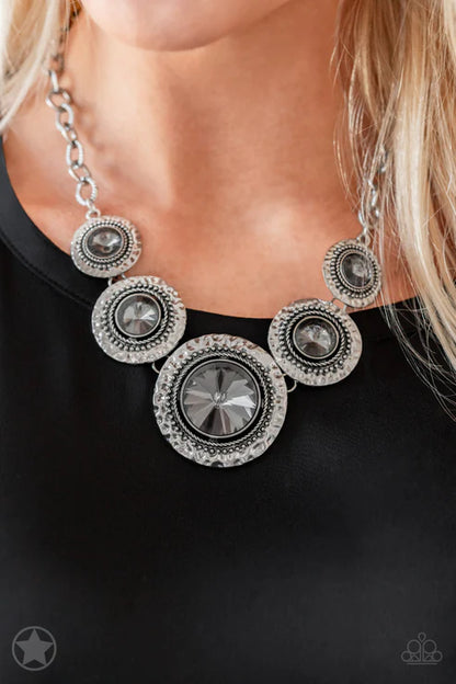 Silver necklace with circular designs on a black background