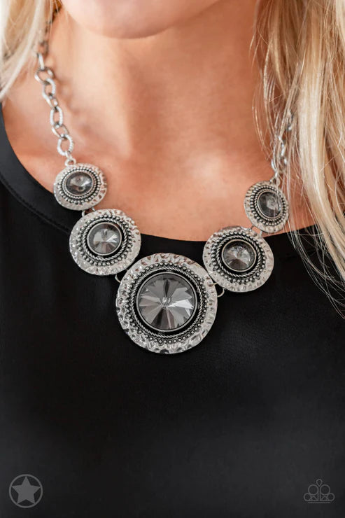 Silver necklace with circular designs on a black background