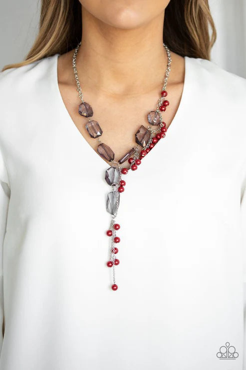 Necklace with red beads and gray stones on a white background