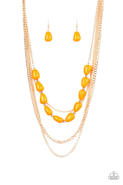 Necklace and earrings set with yellow beads and gold chains on a white background