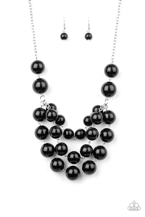Black beaded necklace and earrings on a white background