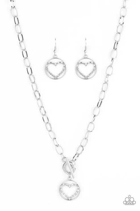 Silver necklace and heart-shaped earrings on a white background