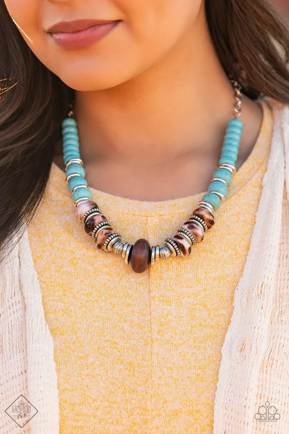 Necklace with turquoise, brown, and silver beads worn by a person in a yellow top.
