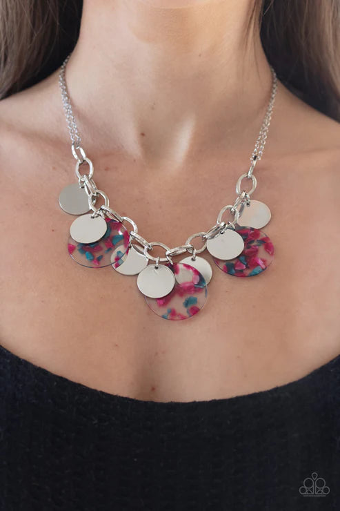Necklace with colorful circular pendants on a person wearing a black top.