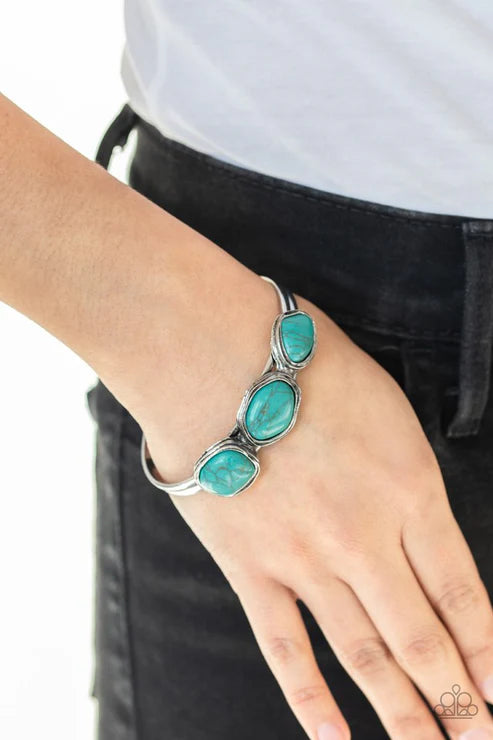Turquoise bracelet on a wrist with a plain background