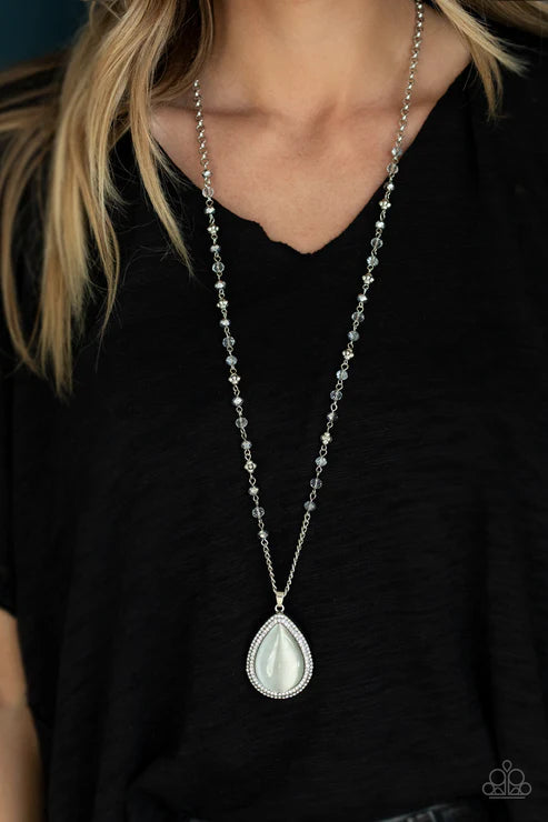 Necklace with a pendant worn by a person against a black background