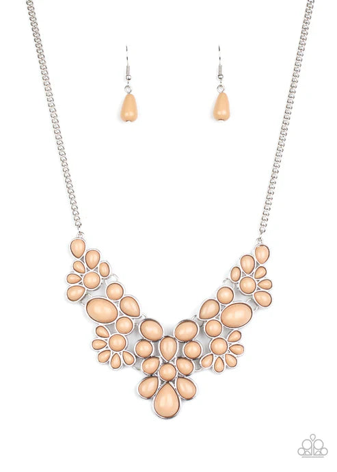 Necklace and earrings set with peach-colored stones on a white background