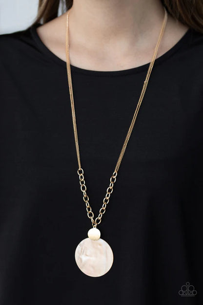 Necklace with a large beige pendant on a black background
