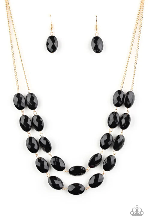 Black beaded necklace and earrings on a white background