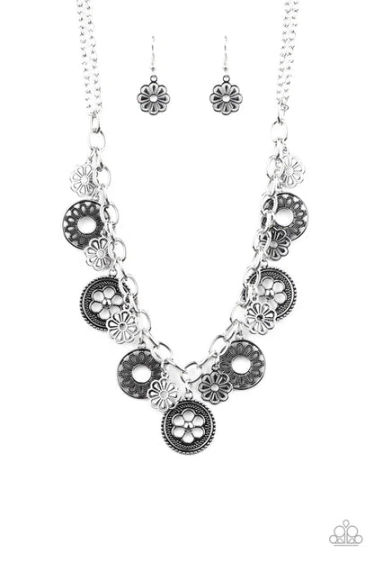 Silver floral necklace and earrings on a white background