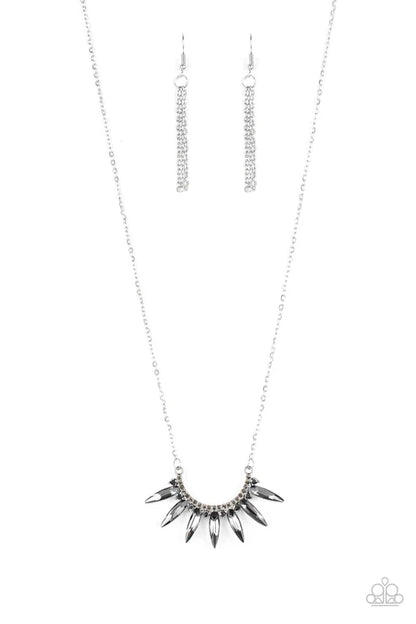Silver necklace with spike-like pendant on a white background