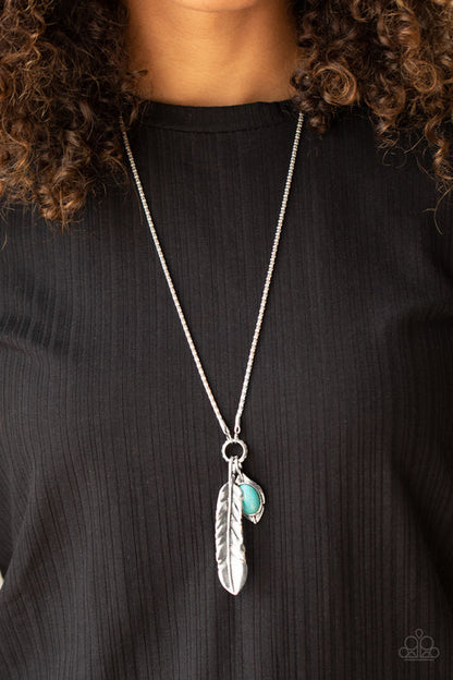 Necklace with feather and green gemstone pendant on a black background