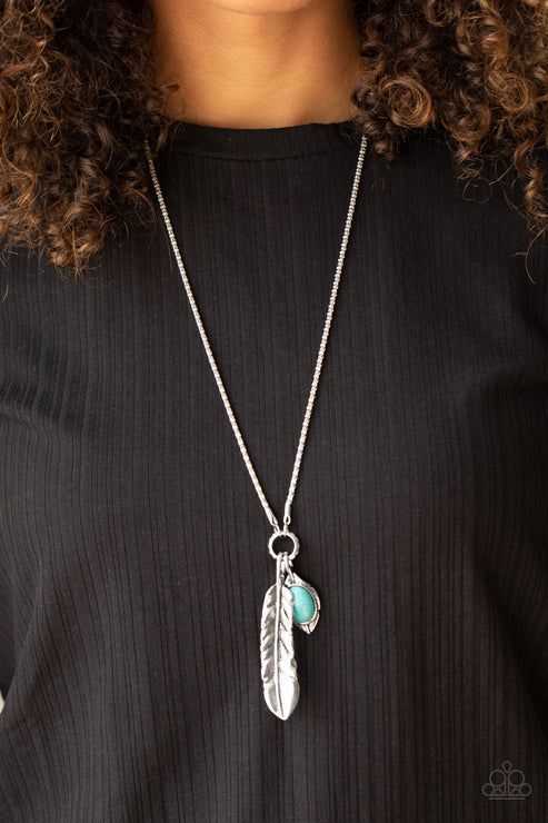 Necklace with feather and green gemstone pendant on a black background