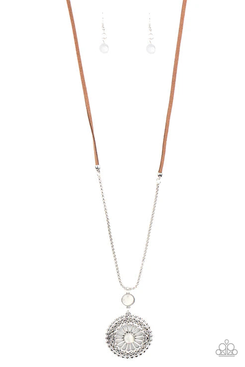 Silver necklace with a circular pendant on a white background