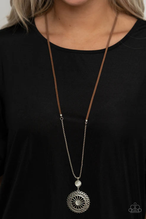 Long necklace with a silver pendant on a black background