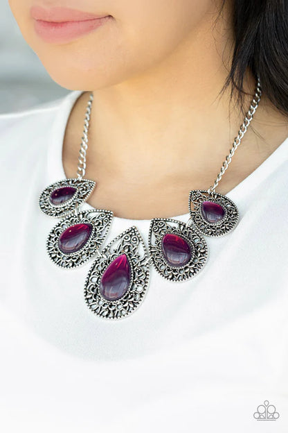 Necklace with purple stones and silver accents worn by a person on a white background