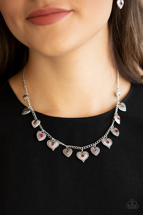 Necklace with heart-shaped pendants worn by a person against a black background