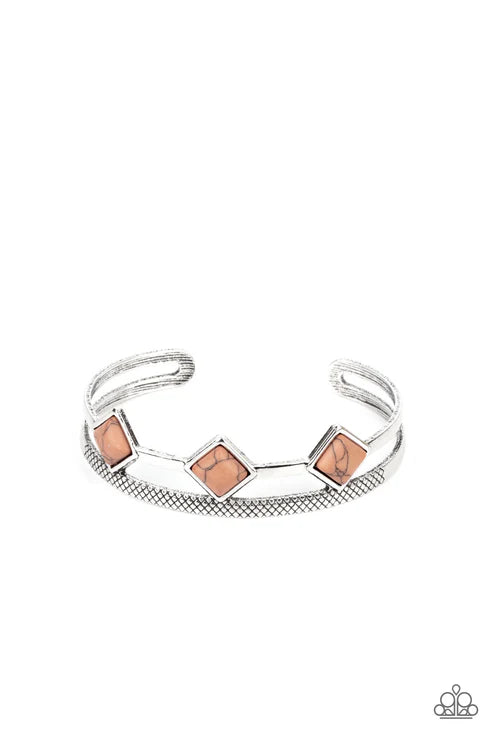 Silver bracelet with pink square stones on a white background