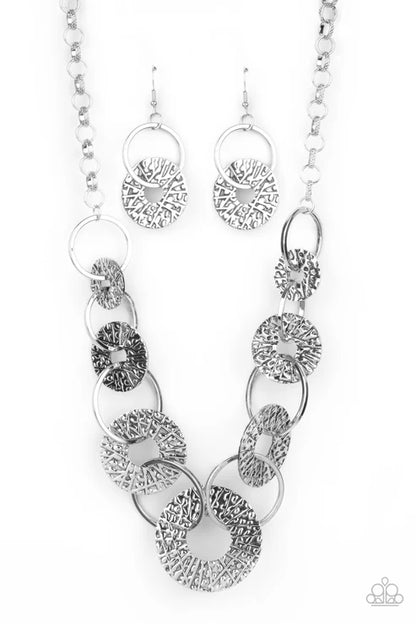 Silver necklace and earrings set on a white background