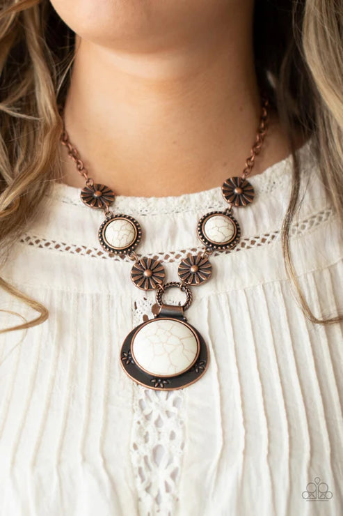 Necklace with floral and circular design on a white blouse