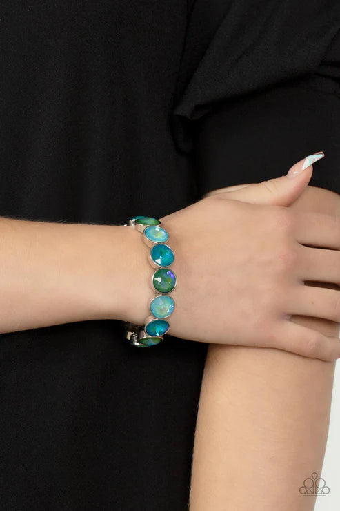 Bracelet with blue gemstones on a wrist against a black background