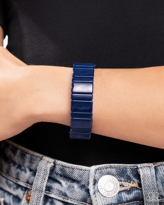 Navy blue bracelet on a wrist with a black shirt and denim jeans background