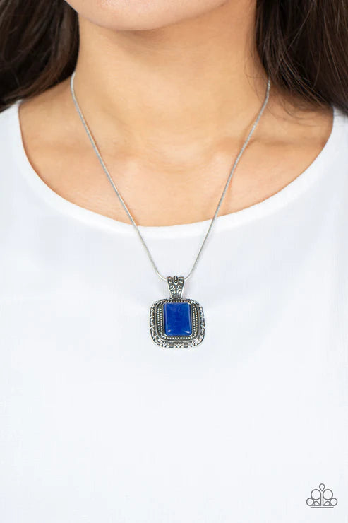 Necklace with a blue pendant worn by a person on a white background