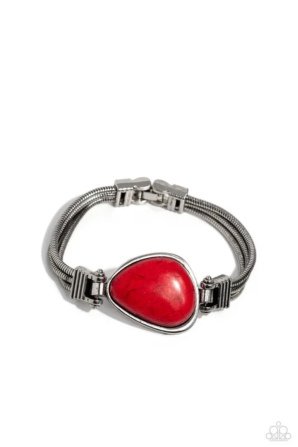 Silver bracelet with a red heart-shaped stone on a white background