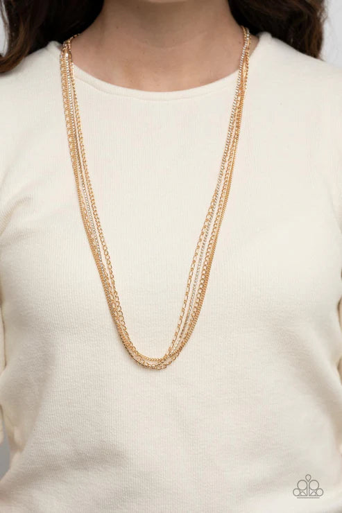 Gold chain necklace on a person wearing a white sweater