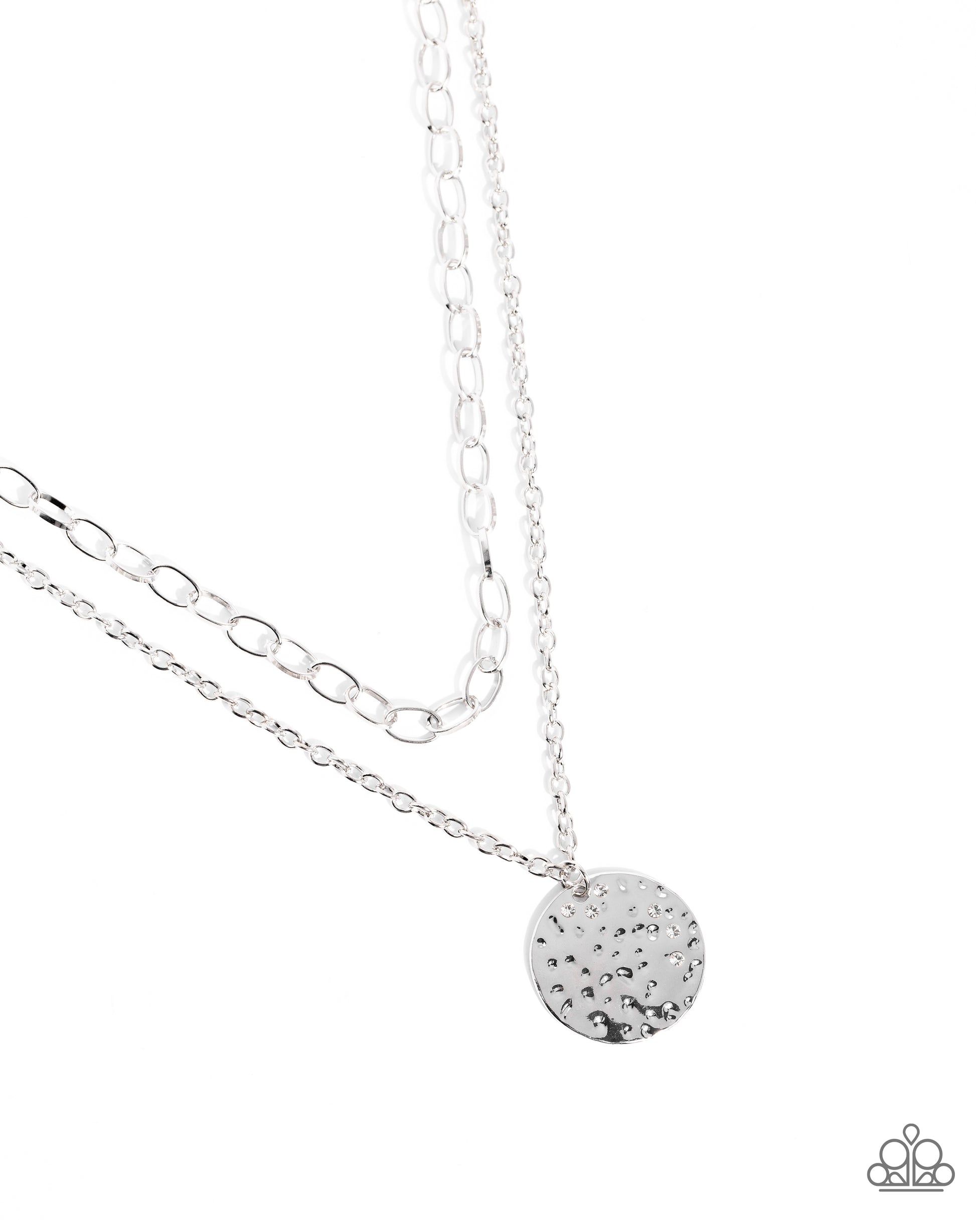 Silver necklace with a round, textured pendant on a white background