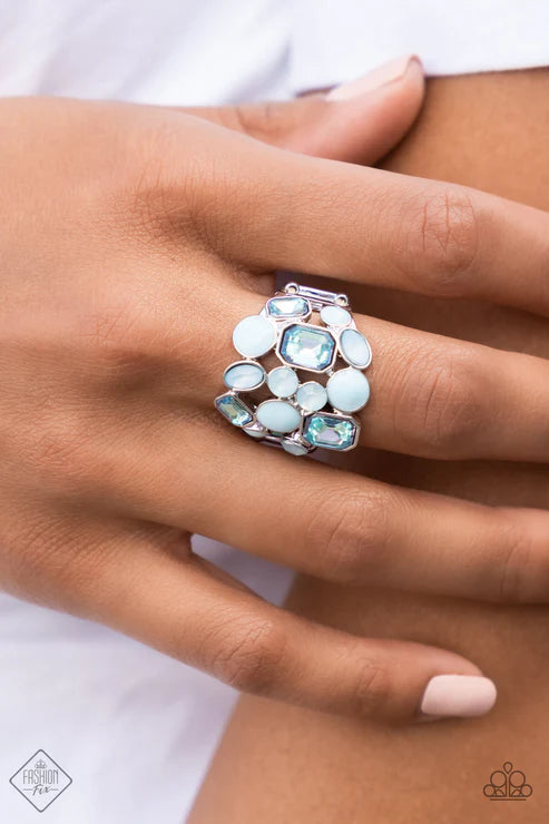 Close-up of a hand wearing a decorative ring with gemstones on a white background
