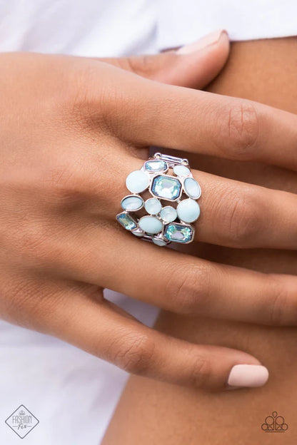 Close-up of a hand wearing a decorative ring with gemstones on a white background
