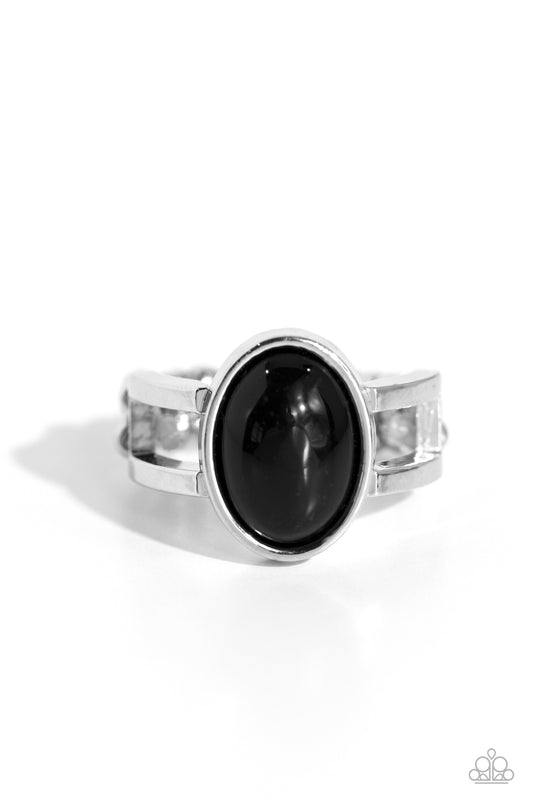 Silver ring with a large black gemstone on a white background