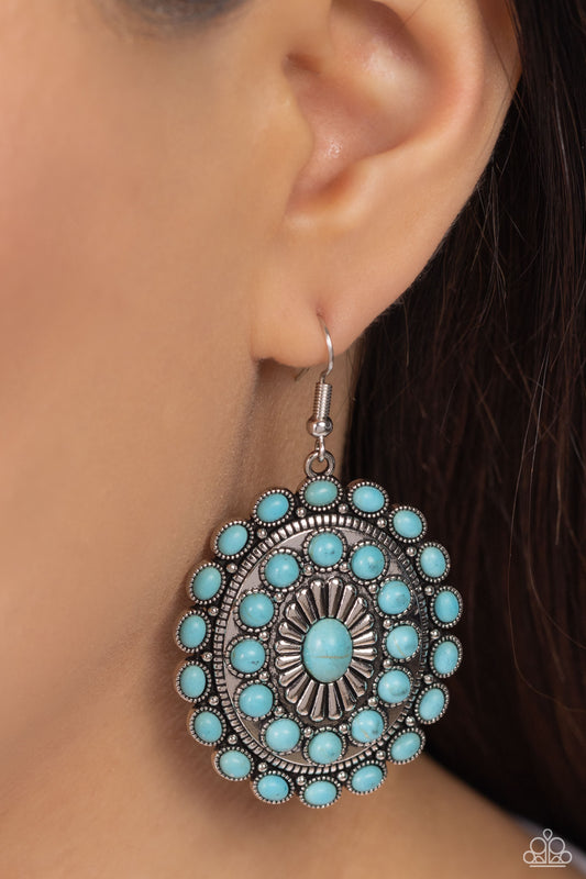 Turquoise beaded earring worn by a person