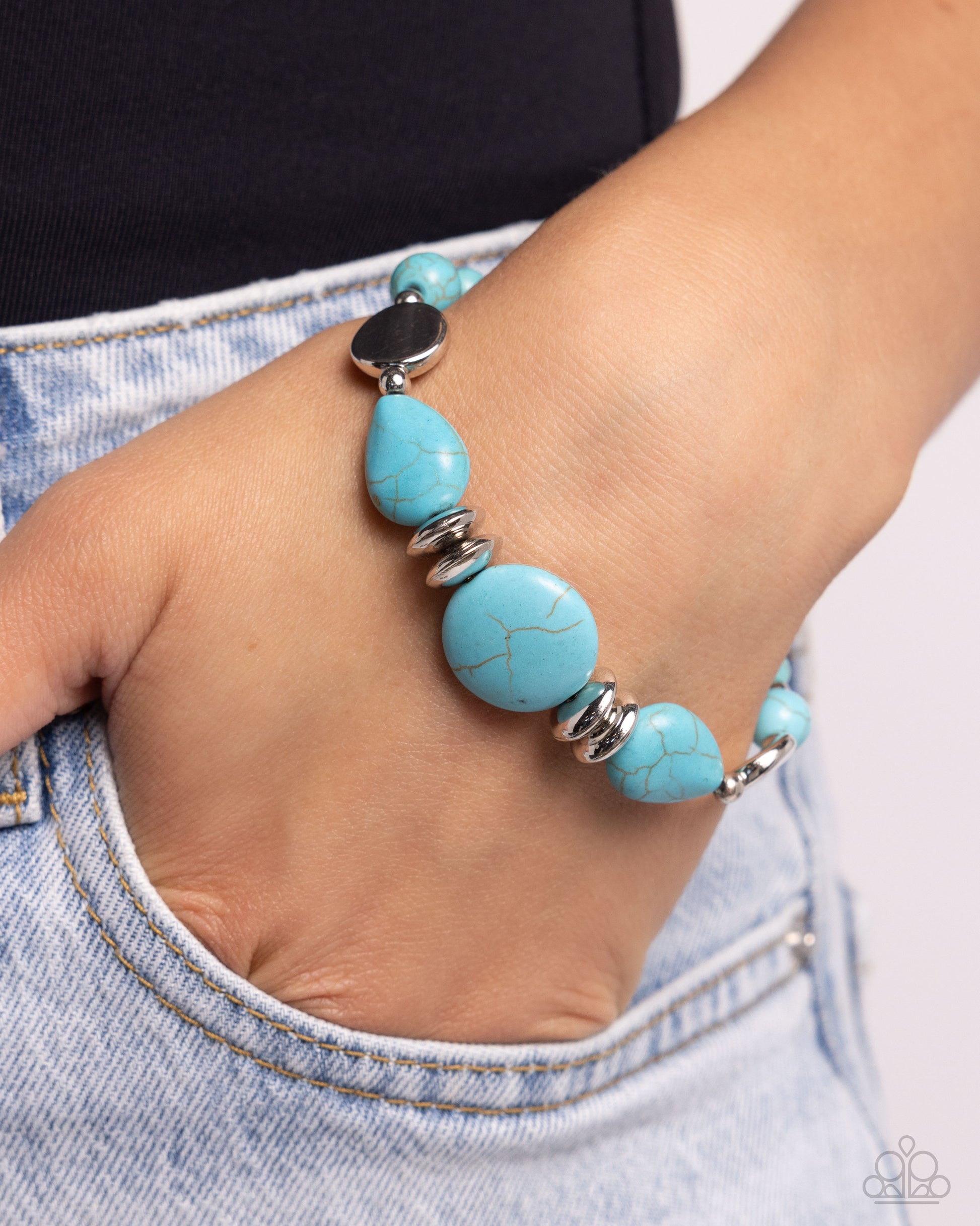 Turquoise beaded bracelet on a wrist with denim background