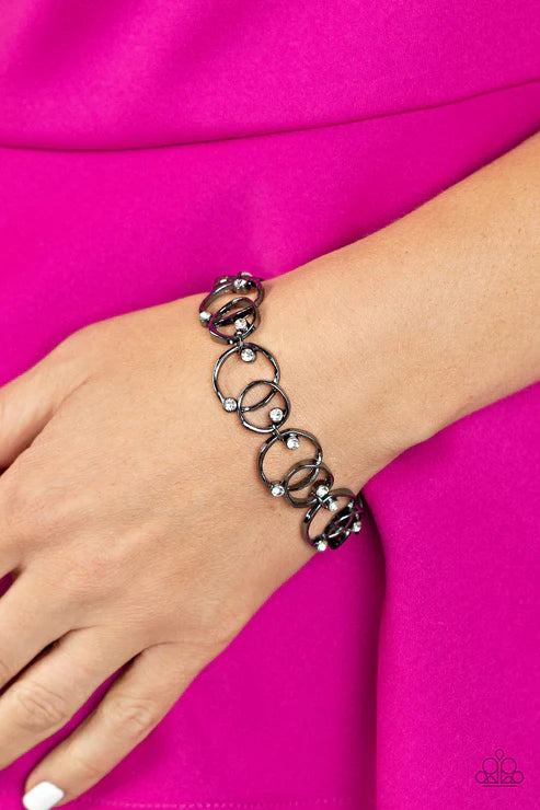 Bracelet on a wrist against a pink background