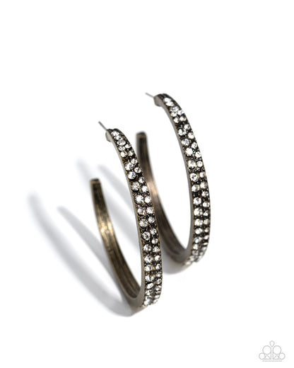 Pair of silver hoop earrings with clear gemstones on a white background