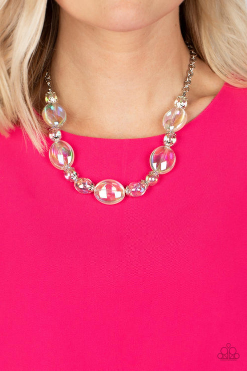 Necklace with pink and clear beads worn by a person against a pink background