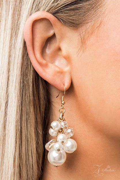 Close-up of a woman's ear wearing a pearl earring with gold accents.