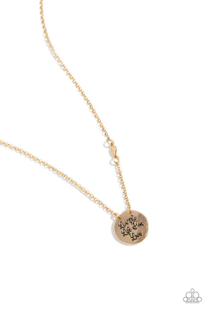 Gold necklace with a round pendant on a white background