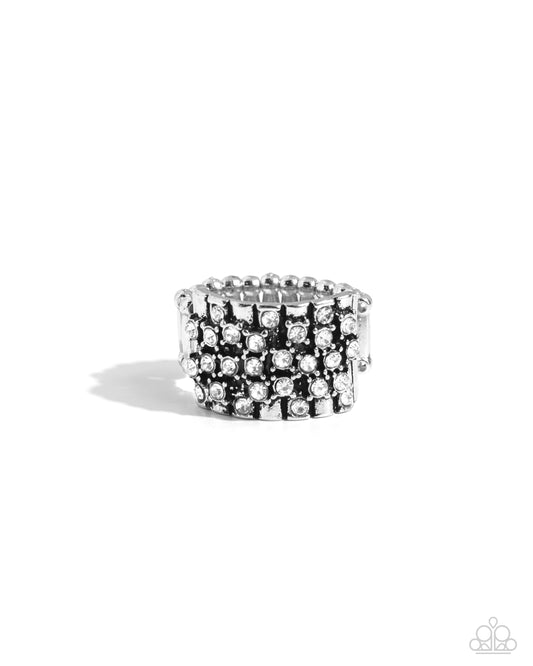 Silver ring with black and clear gemstones on a white background