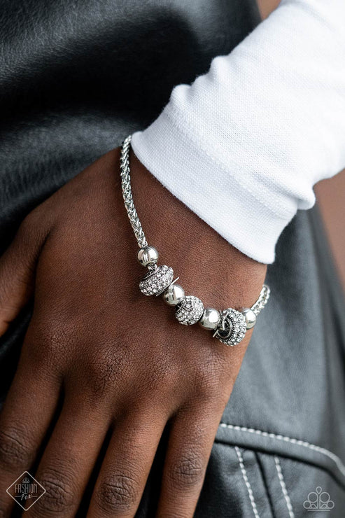 Silver beaded bracelet on a wrist with a blurred background