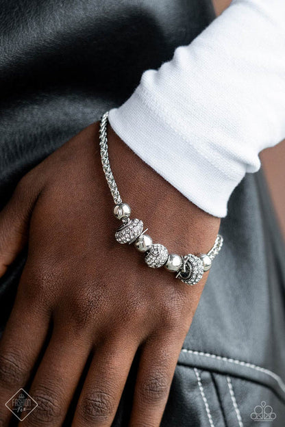Silver beaded bracelet on a wrist with a blurred background