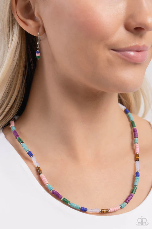 Close-up of a woman wearing a colorful beaded necklace and earrings.