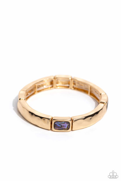 Gold ring with a purple gemstone on a white background