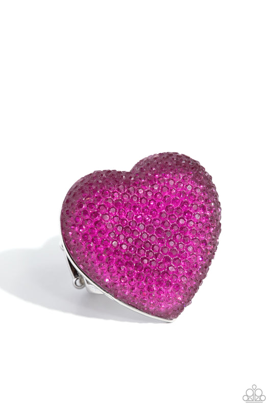Pink heart-shaped clip with rhinestones on a white background