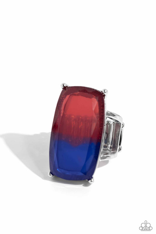 Ring with red, blue, and clear gemstones on a white background