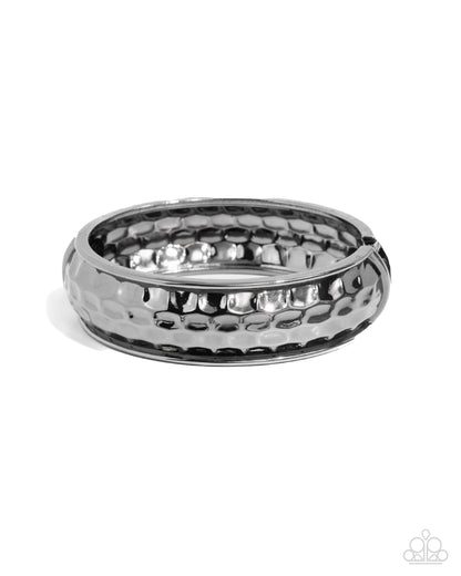 Silver ring with textured design on a white background